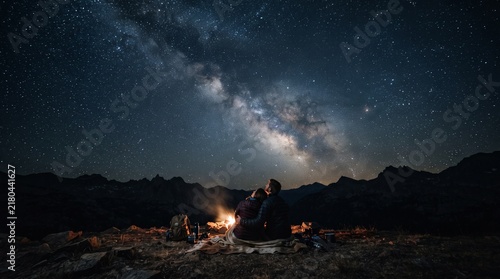 Stargazing campfire under the Milky Way galaxy in a remote desert night