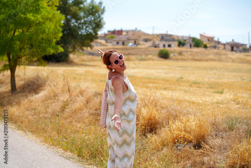 Foto Woman smiles with head tilted, basking in sun