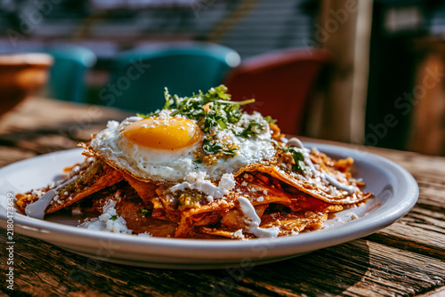 Traditional Mexican chilaquiles with green salsa and fried egg 