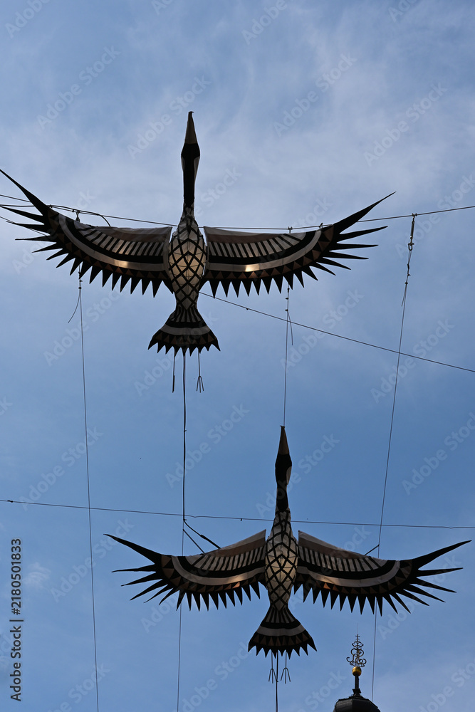 Fototapeta premium Artistic installation of construction cranes rising above the historic Old Town of Lublin, Poland, contrast between contemporary public art and traditional architecture. Poland, Lublin - May 10 2026
