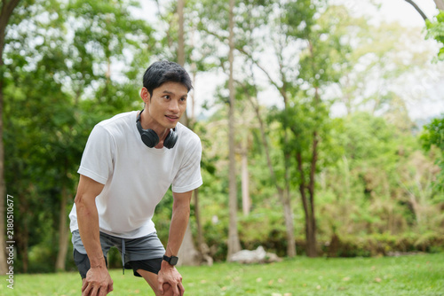 Fotografie Asian man resting after running workout in park for fitness and stamina