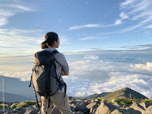 Obraz na płótnie 静かな山頂に立ち豊かな自然と雲海の壮大なパノラマを見下ろす女性