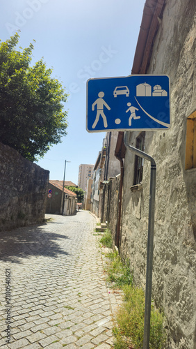 Fotografie Blue residential street sign marks a shared pedestrian and vehicle zone in Portugal
