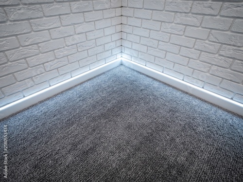 Modern interior corner detail with bright LED floor strip lighting and textured brick walls featuring contemporary ambient home illumination