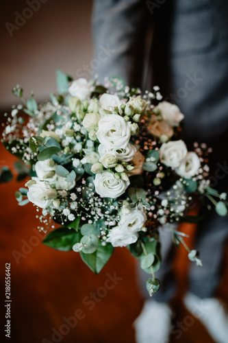 Bild auf Leinwand Bridal bouquet with hand and suit as wedding decoration