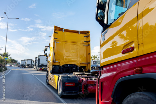 Fotografie Long queue of commercial trucks waiting in line on a highway near the coast