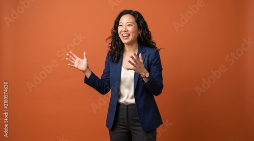 Happy Businesswoman with Curly Hair Expressing Joy in Professional Setting Against Orange Background