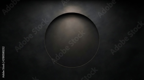 Abstract dark circular depression with subtle overhead lighting on a textured background, creating a minimalist and mysterious visual effect.