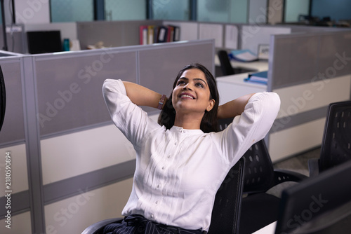 Obraz na plátně Indian working woman relaxing while break to sir on her desk, enjoying a serene moment at work