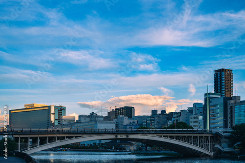 夕暮れ時の美しい雲と川に架かる大きな橋と都市風景