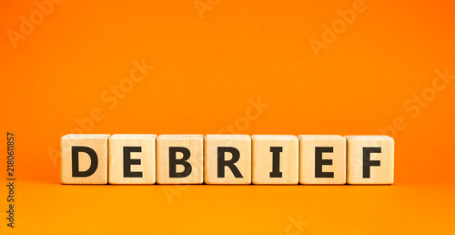 Debrief word symbol. Concept word Debrief on beautiful wooden blocks. Beautiful orange table orange background. Business debrief word concept. Copy space.