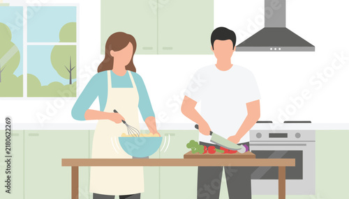 Young couple preparing a healthy meal together in a modern kitchen while whisking ingredients and chopping vegetables.