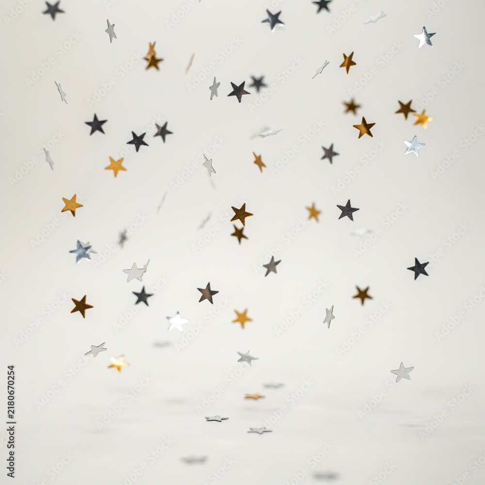 Fototapeta premium Scattered Gold Silver and Black Star Confetti on White Background