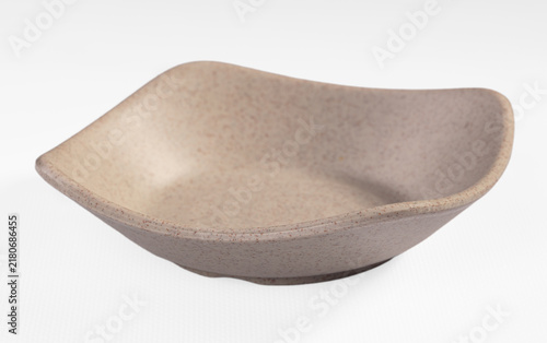 Quadro su tela Beige speckled ceramic bowl with asymmetrical shape on white background