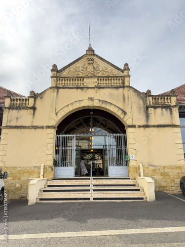 Ornate 1886 covered market hall entrance with pediment and coat of arms, Gers, Mirande, France