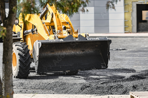 Konstfotografi A large loader is moving asphalt in a construction area
