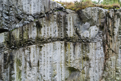 Fotografía Rugged quarry granite rock wall with tool marks and natural mineral veins
