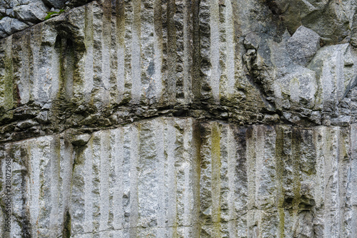 Textured rock wall background with vertical lines and natural stone surface