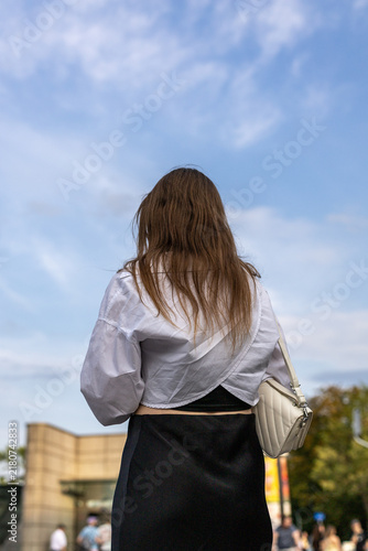 young woman in the city against a blue sky