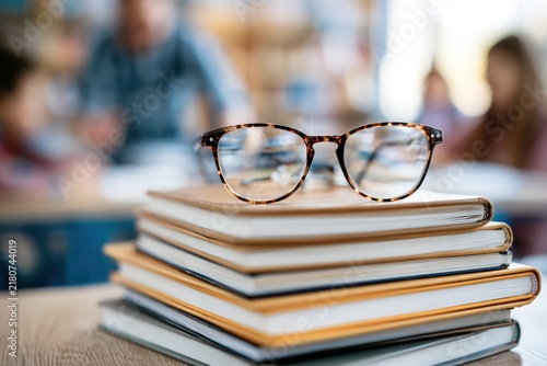 Eyeglasses on books in school classroom