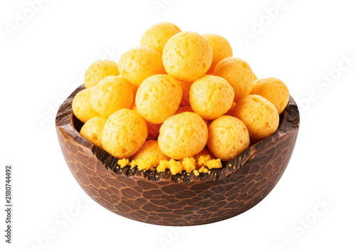 Round baked cheese balls piled in a rustic wooden bowl with crumbs scattered on transparent background.