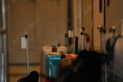 Obraz na płótnie A hotel bellboy with guest luggage, lifting suitcases onto a brass luggage trolley in a luxury hotel lobby by the luggage cart, in a stylish contemporary hospitality setting