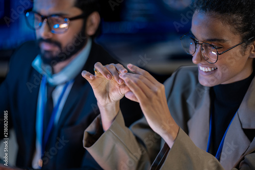 Foto Close-up of bionic prosthetic hands in a darkroom lit by blue AI displays during a technology demonstration event at night