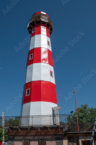 Картината върху платно Newly painted red and white lighthouse in midday sunlight.