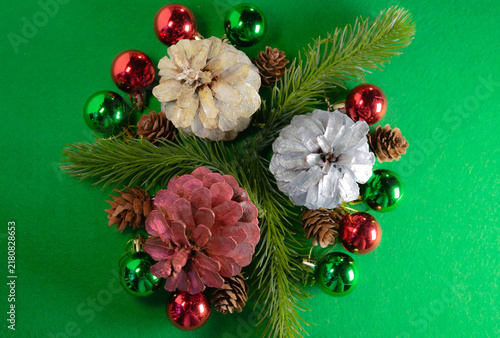 Obraz na płótnie “Christmas still life with pinecones and decorations on a green background”