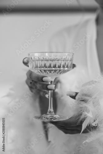 Black and white shot of bride holding vintage champagne coupe