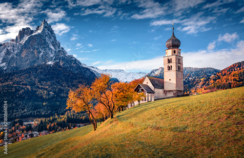 Astonishing morning view of snowy Petz peak and St. Valentin ( Kastelruth ) church in autumn garden. Majestic autdoor scene of Kastelruth village, Dolomite Alps, Italy. Traveling concept background.