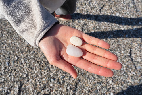 Hand Holding Smooth Pebbles on a Beach in Milazzo