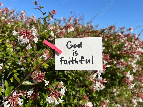 God is faithful - christian motivational concept from the Bible, with flowers on background