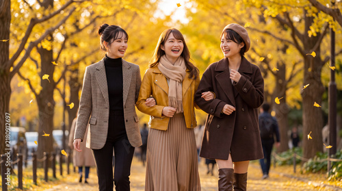 Plakat イチョウ舞い散る並木道を腕を組んで楽しそうに歩く女性3人（秋の行楽・女子旅・散策）