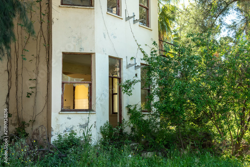 Принти на полотні An abandoned overgrown hotel braided with beautiful flowering plants