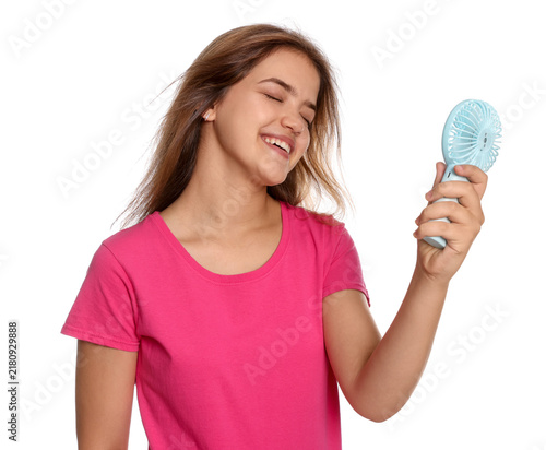 Cuadro en lienzo Smiling teenage girl cooling down with portable mini fan on white background