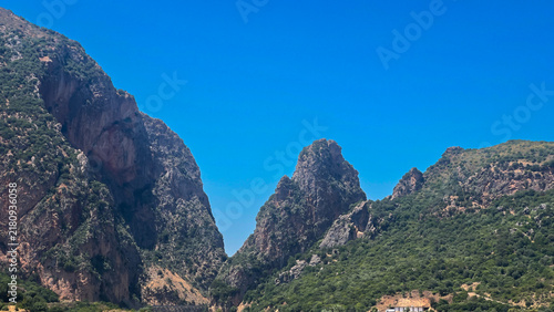 Rocky Mountain and Lush Valley Under Clear Blue Sky