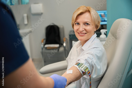 Caucasian woman preparing to draw blood in medical room