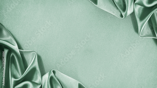 Light soft green mint celadon silk satin. Shiny silky fabric. Wavy fold draped. Elegant luxury background. Empty blank space template design ad. Christmas birthday. Flat lay, top view table.