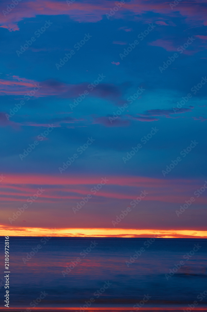 Fototapeta premium Colorful Tropical Sunset Over Calm Ocean with Dramatic Purple and Orange Sky