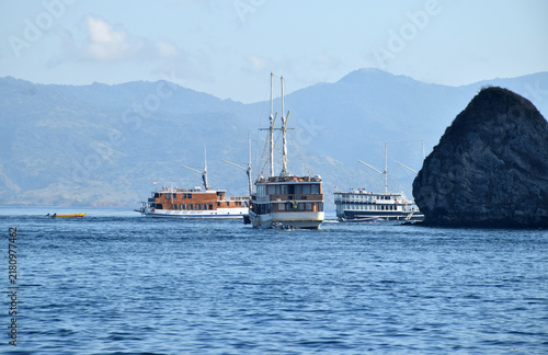 A Phinisi boat carrying tourists amidst the beautiful, rugged hills of the Komodo National Park area, Labuan Bajo, Indonesia