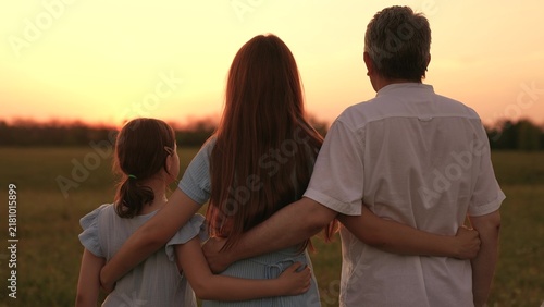Obraz na plátne Happy family, father mother child hugging sunset, girl hugging parents man woman