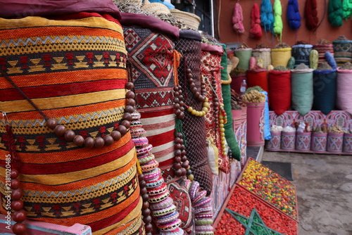 Colorful traditional market display with textiles and herbs in Marrakech, Morocco