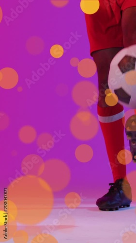 Animation of lens flares over low section of african american player dribbling soccer ball