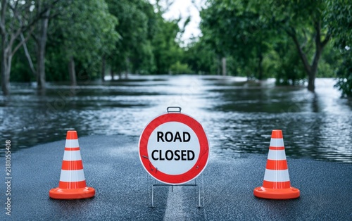 Severe Flooding Causes Roadway Blockage in Suburban Area with Warning Sign and Cone Barriers