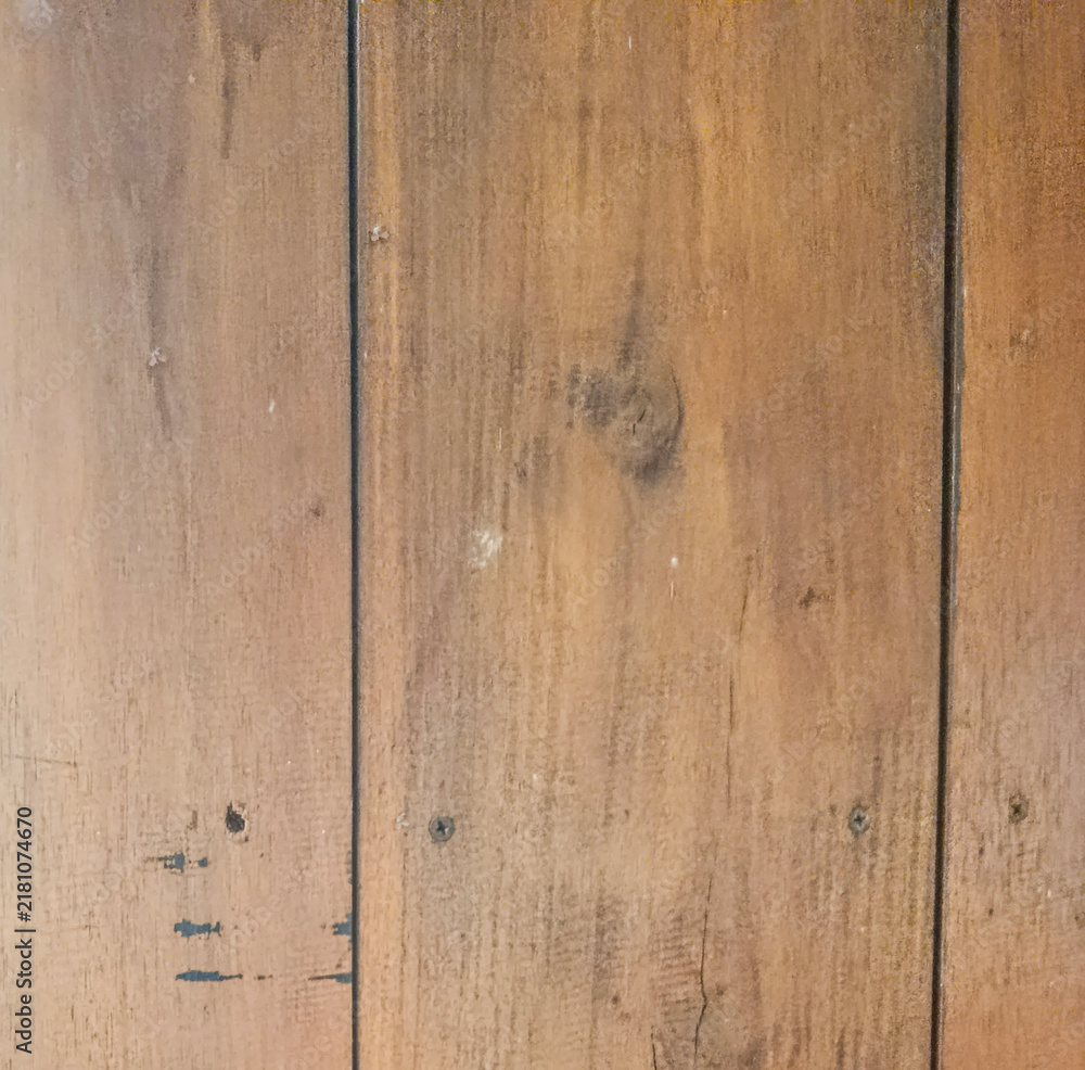 Fototapeta premium Close-up permukaan panel kayu cokelat dengan serat vertikal, sambungan gelap, sekrup, noda, dan bekas pemakaian yang memberi karakter rustic.
