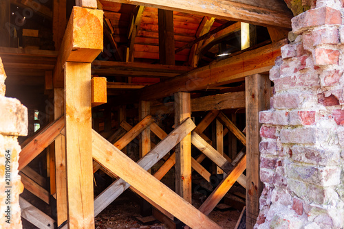 Fotografie Wooden scaffolding and sturdy timber support beams reinforcing the crumbling wal