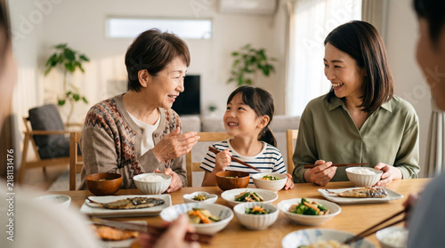 明るいリビングで和食の夕食を笑顔で囲む三世代家族