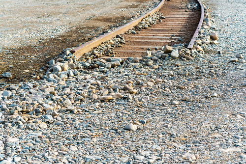 Фотография Disused and broken railway tracks disappearing into the stony ground as a conceptual metaphor for obstacles, failure, and blocked progress