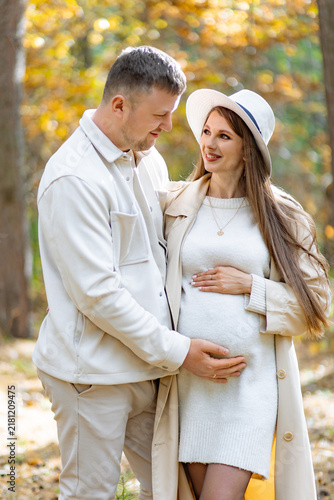 Fotografie A loving couple expecting a baby enjoys a beautiful day in the park, surrounded